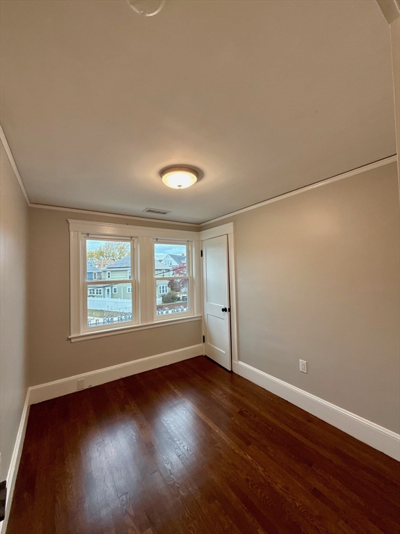 224 Faneuil Street, Unit 1 Boston, MA 02135 - Photo 14 of 19 an empty room with wooden floor and windows