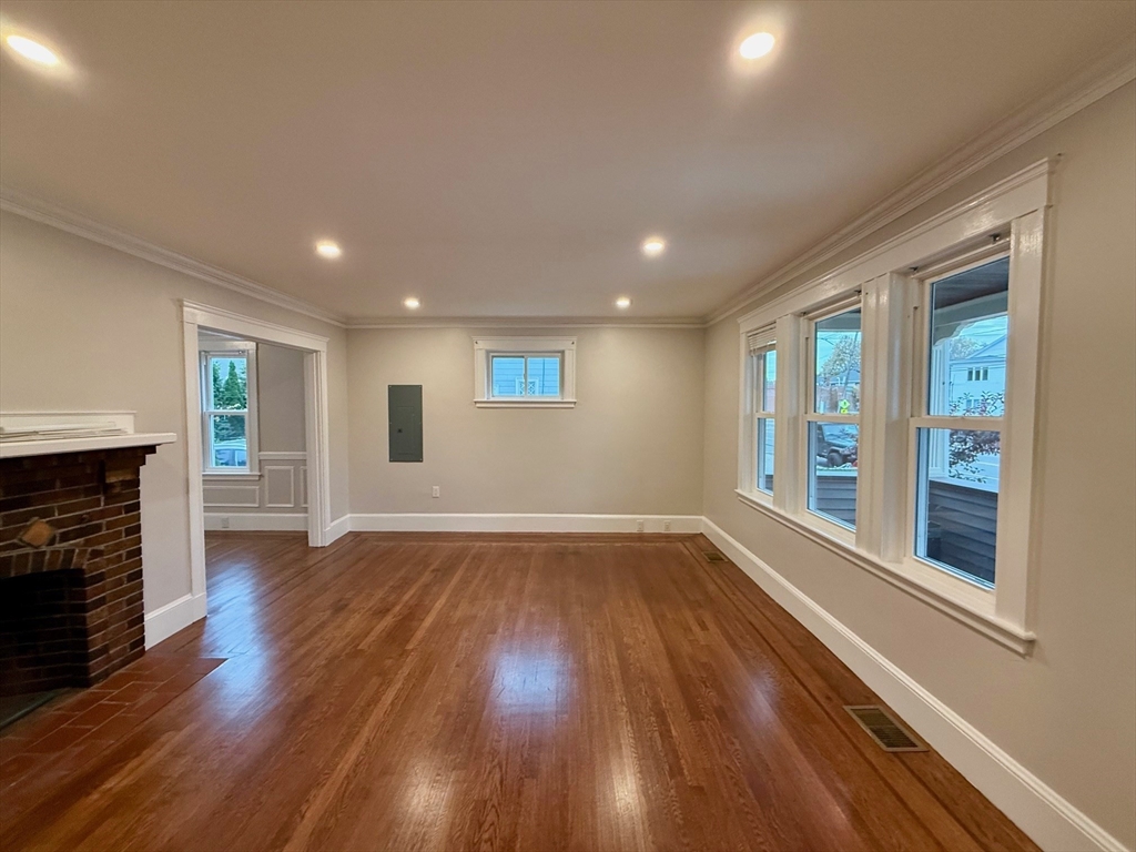 224 Faneuil Street, Unit 1 Boston, MA 02135 - Photo 3 of 19 a view of an empty room with wooden floor and a window