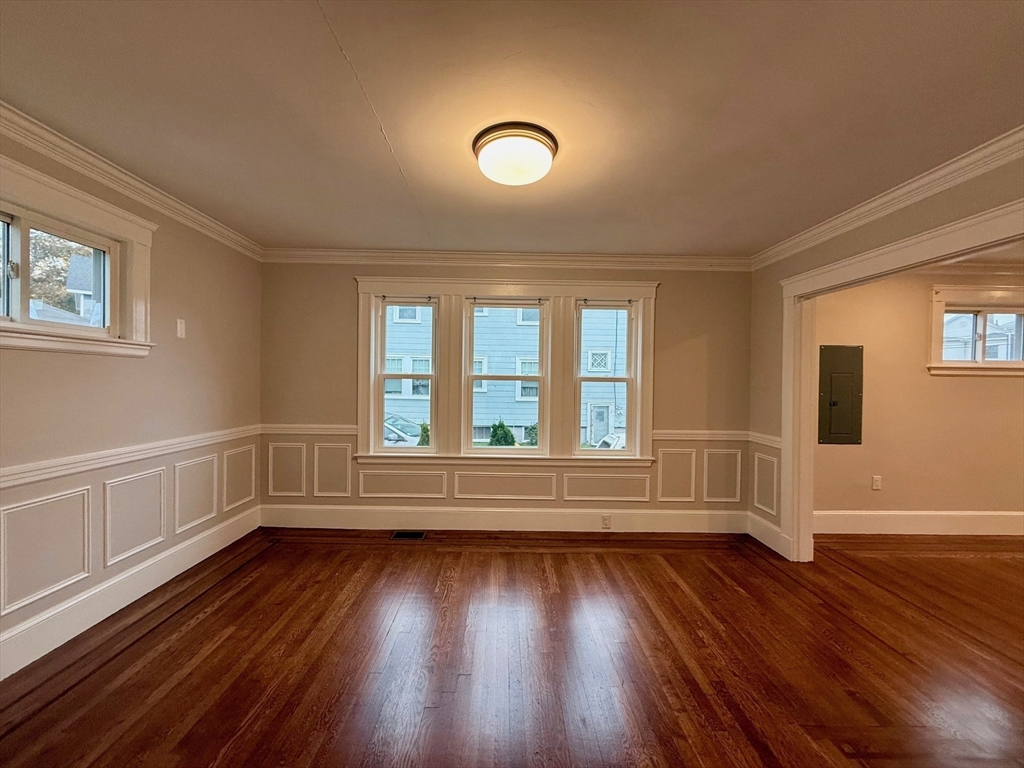 224 Faneuil Street, Unit 1 Boston, MA 02135 - Photo 4 of 19 a view of empty room with wooden floor and fan