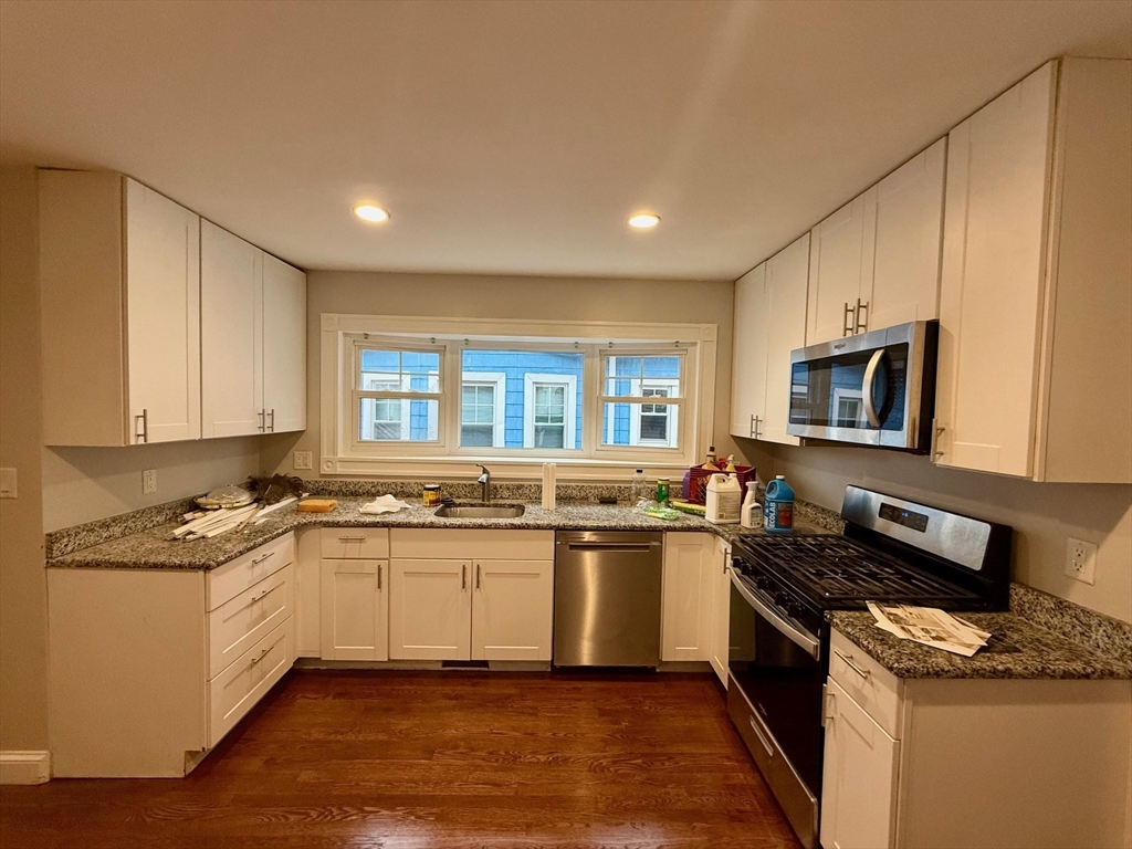 224 Faneuil Street, Unit 1 Boston, MA 02135 - Photo 6 of 19 a kitchen with stainless steel appliances granite countertop a stove a sink and a microwave