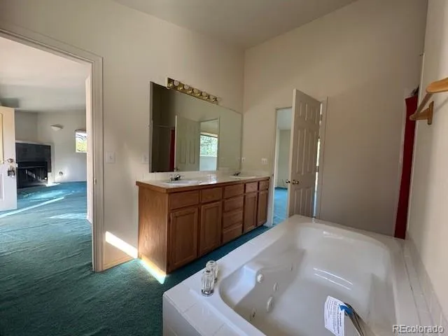 a bathroom with a tub sink and mirror