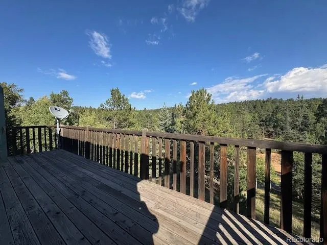 a view of a balcony with wooden floor & fence