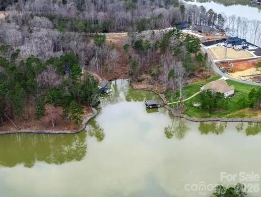 an aerial view of residential houses with outdoor space and lake view