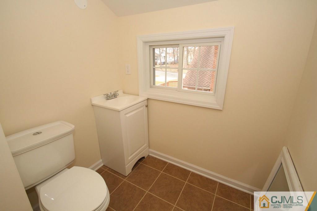 305 Chain O' Hills Road Colonia, NJ 07067 - Photo 12 of 20 a white toilet sitting in a bathroom next to a window