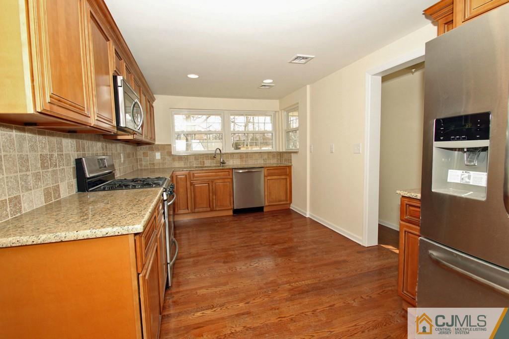 305 Chain O' Hills Road Colonia, NJ 07067 - Photo 3 of 20 a kitchen with stainless steel appliances granite countertop a sink and a refrigerator
