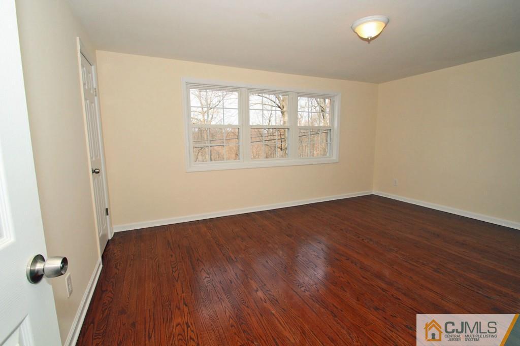 305 Chain O' Hills Road Colonia, NJ 07067 - Photo 8 of 20 an empty room with wooden floor and windows