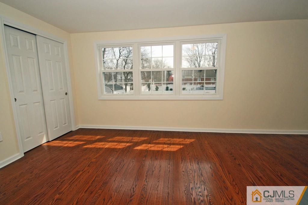 305 Chain O' Hills Road Colonia, NJ 07067 - Photo 9 of 20 a view of an empty room with wooden floor and a window