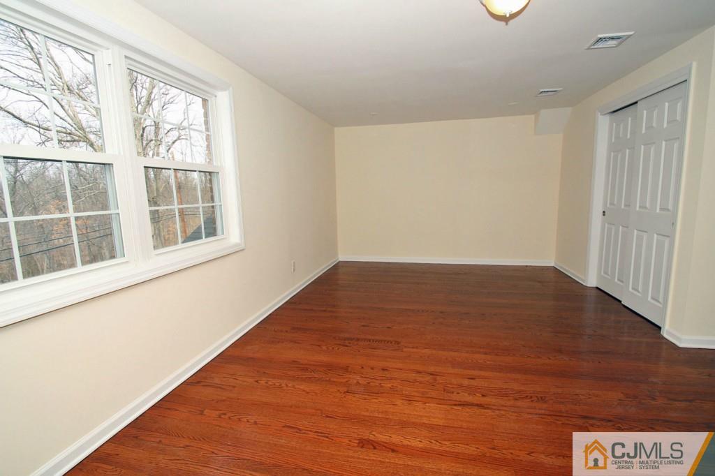 305 Chain O' Hills Road Colonia, NJ 07067 - Photo 10 of 20 an empty room with wooden floor and windows