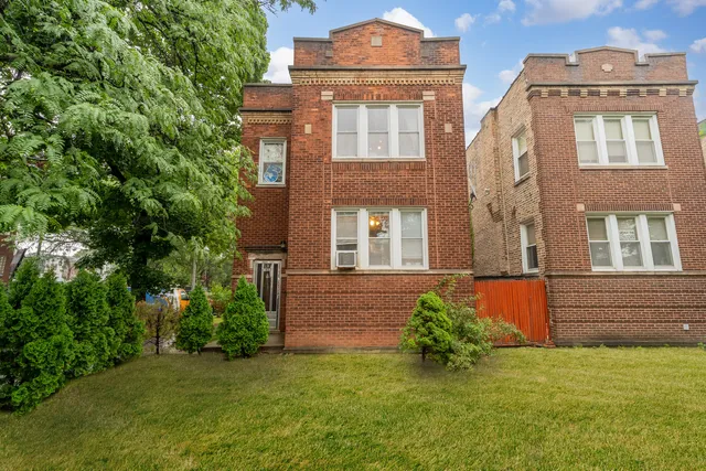 front view of a brick house with a yard