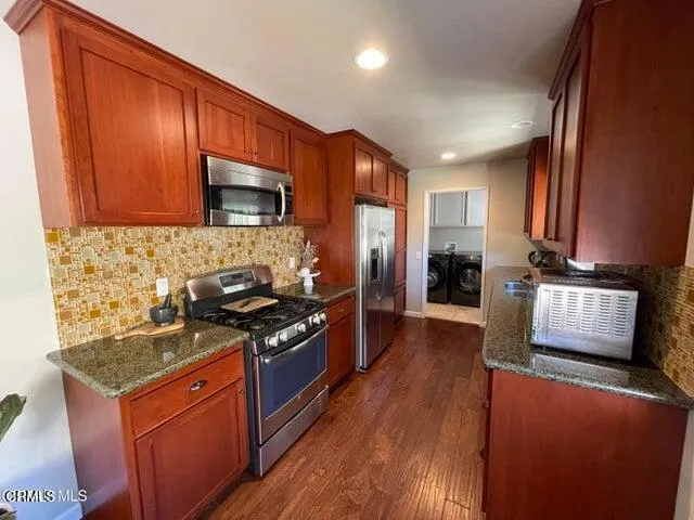 a kitchen with stainless steel appliances granite countertop a stove a sink dishwasher and a refrigerator