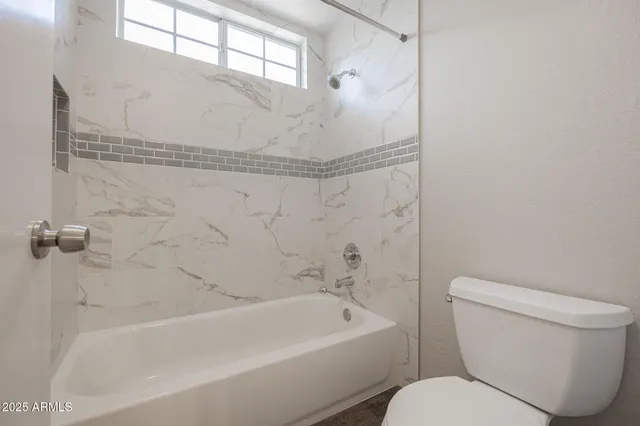 a bathroom with a toilet and bathtub