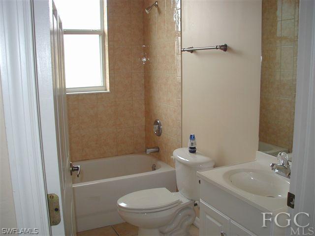 17552 Duquesne Road Fort Myers, FL 33967 - Photo 8 of 10 a bath room with a toilet a sink and a bath tub