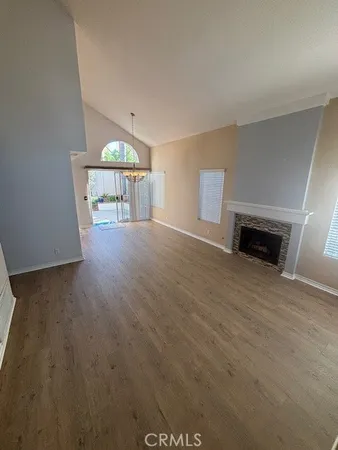 a view of a livingroom with wooden floor and a fireplace