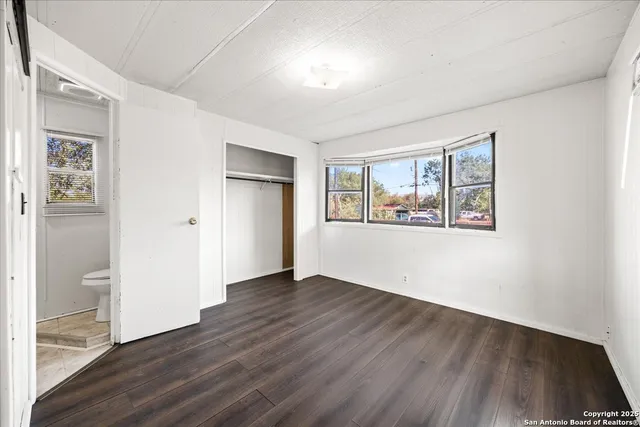 an empty room with wooden floor and a window
