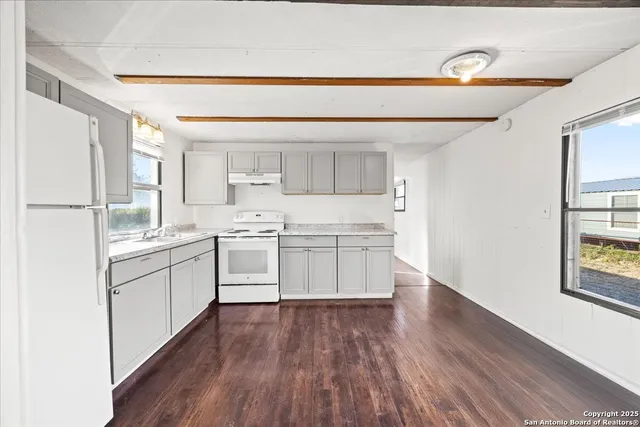 a kitchen with white cabinets and white appliances