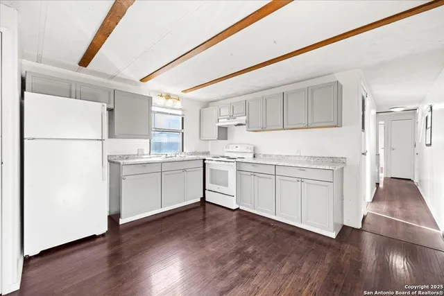 a kitchen with white cabinets and white appliances