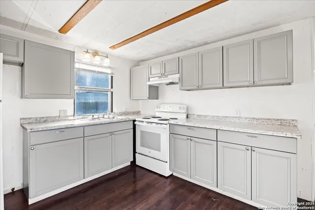a kitchen with granite countertop white cabinets and white appliances