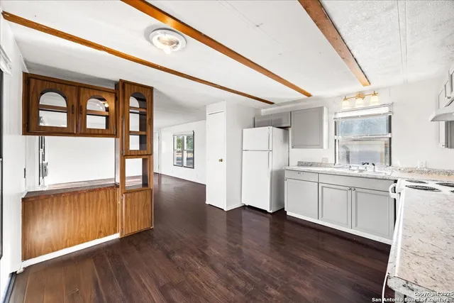 a view of a kitchen with wooden floor and electronic appliances