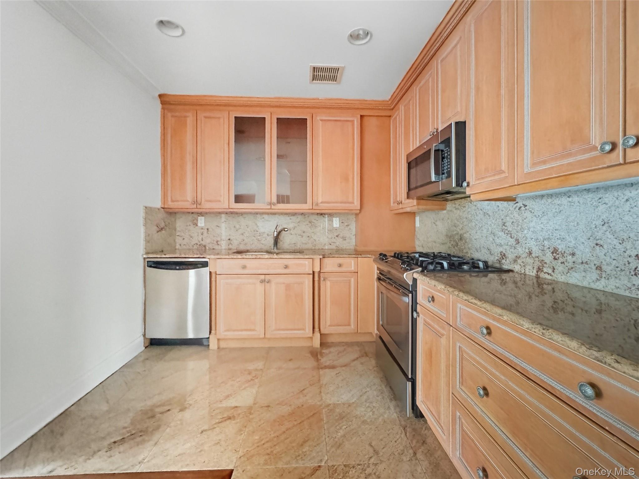 171 Great Neck Road, Unit 1C Great Neck, NY 11021 - Photo 6 of 17 a kitchen with stainless steel appliances granite countertop a stove and a sink
