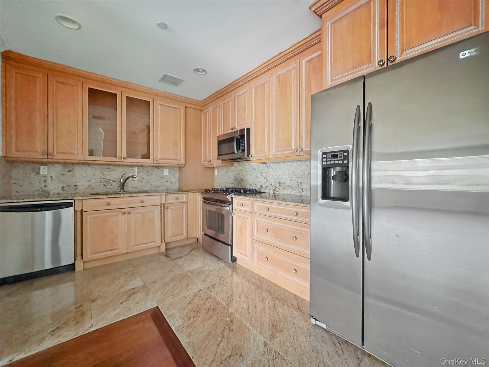 171 Great Neck Road, Unit 1C Great Neck, NY 11021 - Photo 7 of 17 a kitchen with a refrigerator sink and cabinets