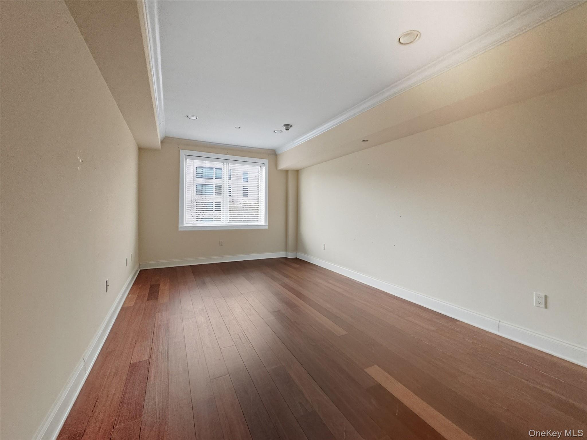 171 Great Neck Road, Unit 1C Great Neck, NY 11021 - Photo 8 of 17 an empty room with wooden floor and window