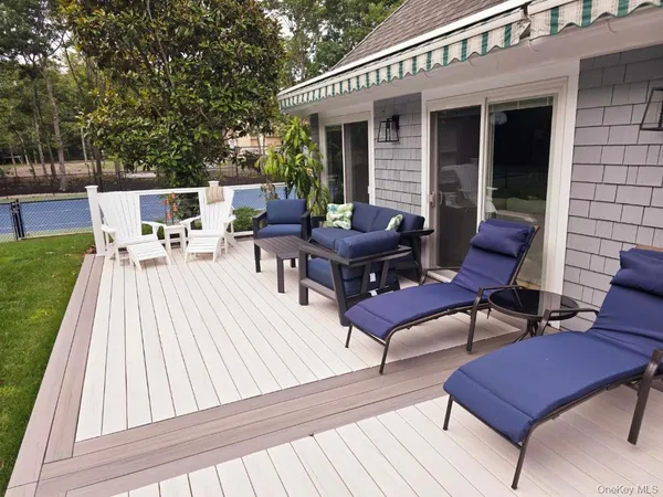 a view of a roof deck with table and chairs with wooden floor and fence