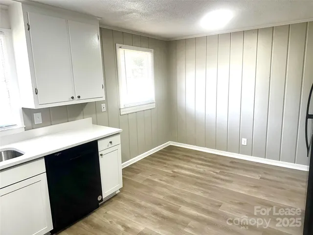 a view of an empty room with cabinet and a window