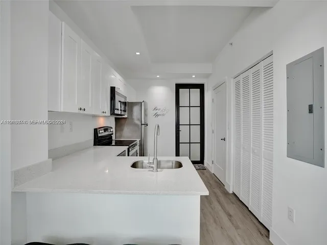 a kitchen with kitchen island a sink appliances and cabinets