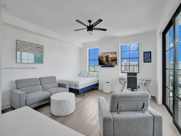 a living room with furniture and a ceiling fan