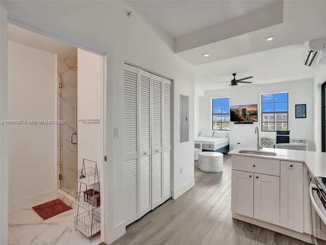 a large white kitchen with a refrigerator a sink dishwasher and a fireplace