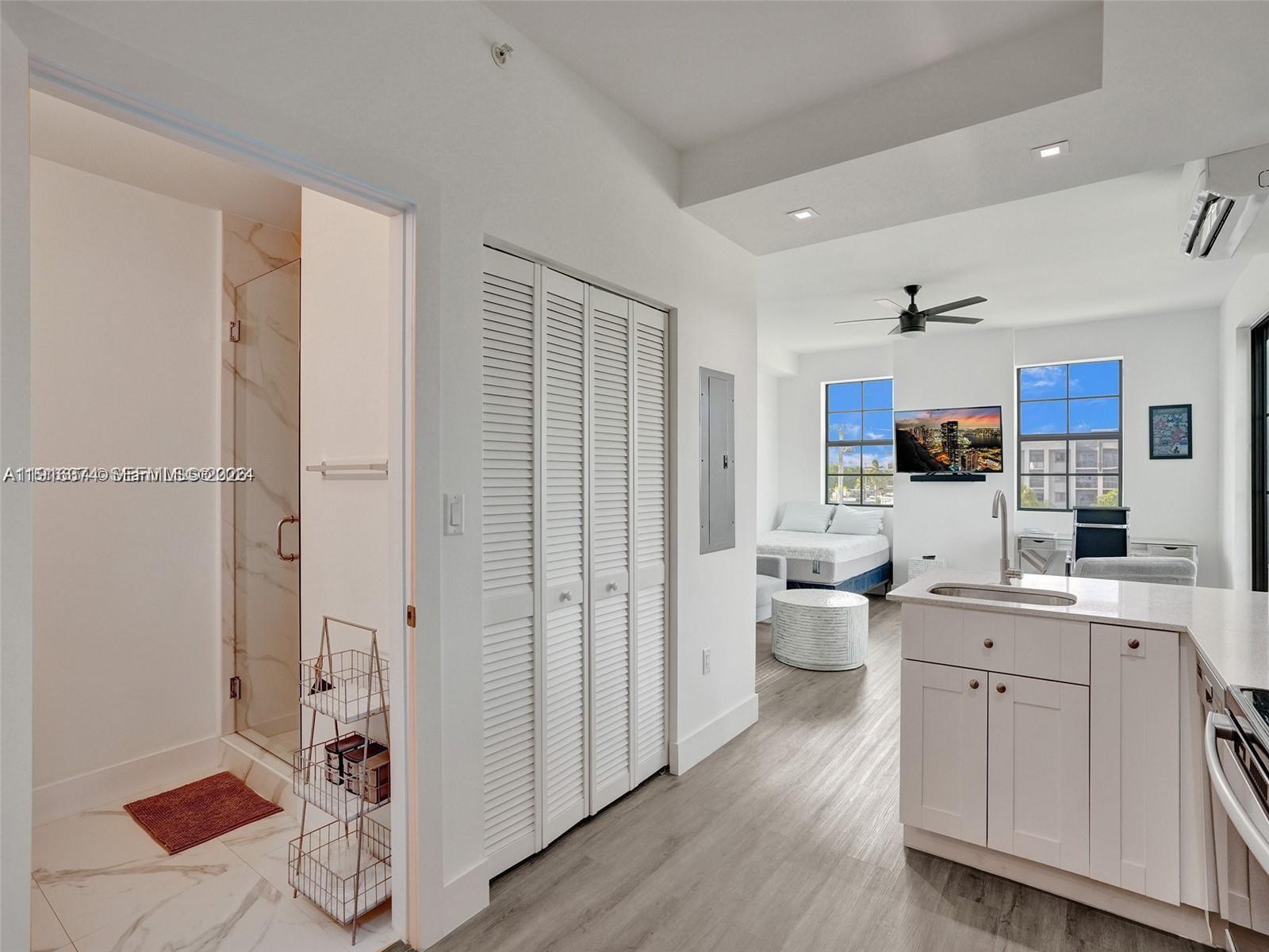 4100 Southwest 64th Avenue, Unit 308 Davie, FL 33314 - Photo 22 of 41 a large white kitchen with a refrigerator a sink dishwasher and a fireplace