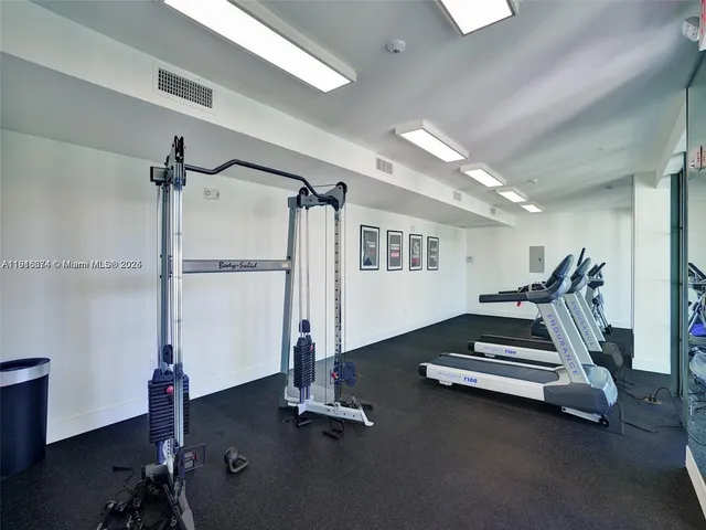 a room with gym equipment and a wooden floor