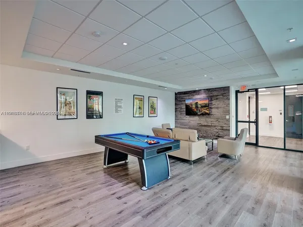 a living room with furniture a large window and wooden floor