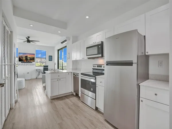 a kitchen with white cabinets and stainless steel appliances