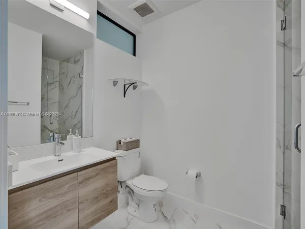 a bathroom with a toilet sink and mirror