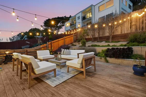a view of a patio with couches and table and chairs and potted plants