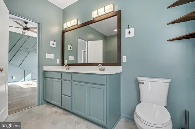 a bathroom with a toilet a sink and mirror