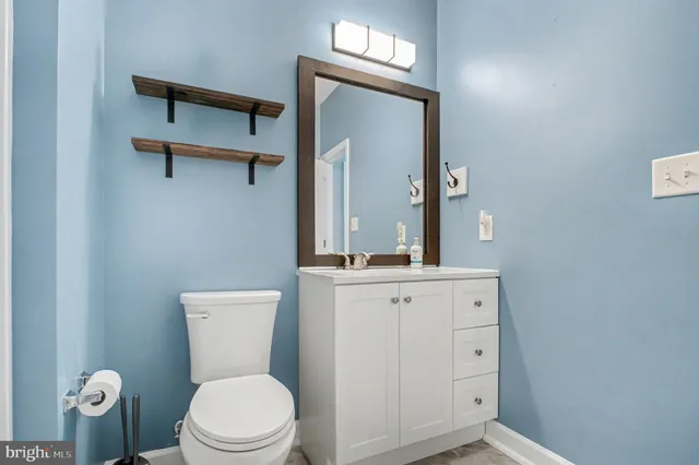 a bathroom with a toilet a sink a vanity and mirror