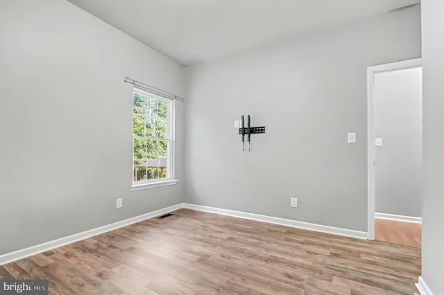 wooden floor in an empty room with a window
