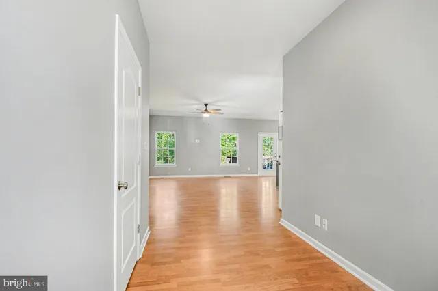 view of a hallway with wooden floor and a large window