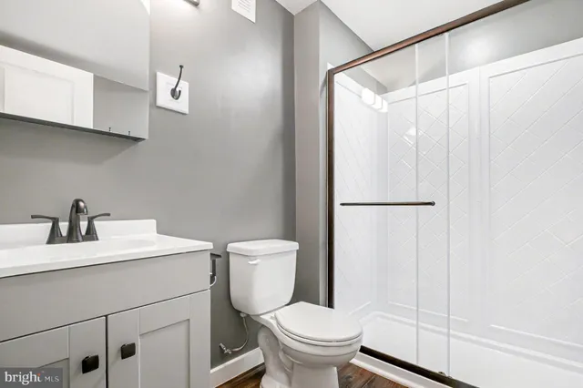 a bathroom with a sink a toilet and shower
