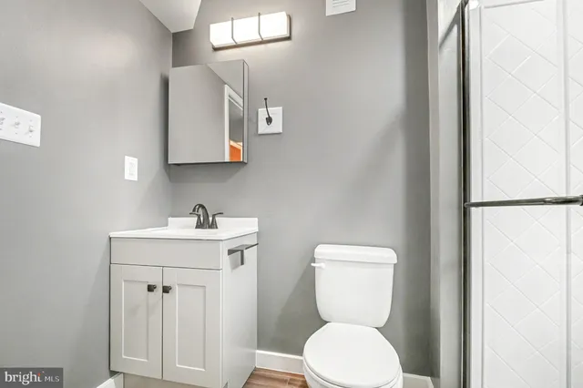 a bathroom with a toilet a sink and mirror