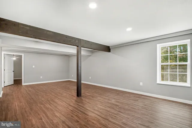 wooden floor in an empty room with a window