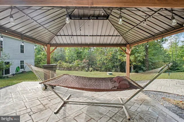 a view of patio with a table and chairs under an umbrella