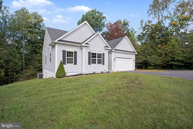 a view of a house with a yard and potted plants