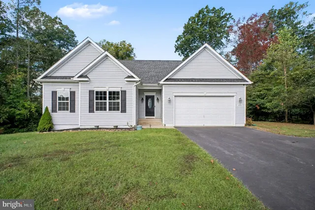 a view of a yard in front of a house with large trees