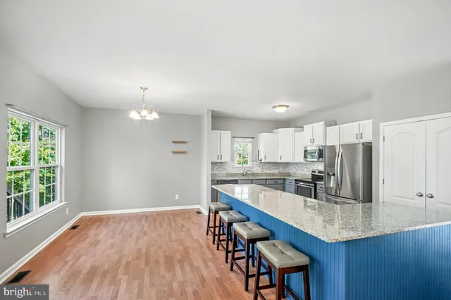 a kitchen with stainless steel appliances granite countertop a sink refrigerator and cabinets