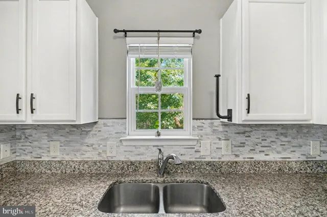 a kitchen with granite countertop a sink and a window