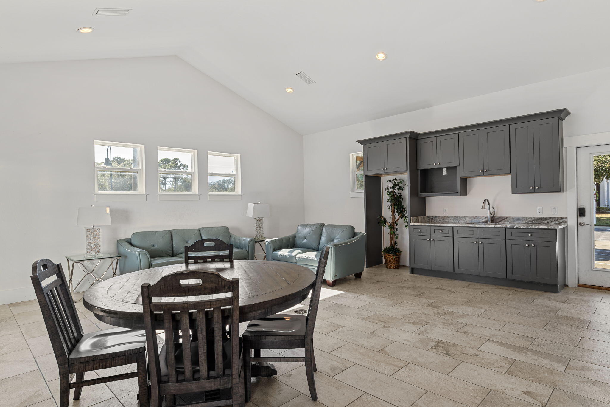 995 Airport Road, Unit 43 Destin, FL 32541 - Photo 38 of 40 a kitchen with a table chairs a sink refrigerator and cabinets