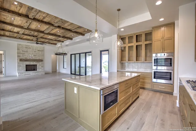 a kitchen with stainless steel appliances granite countertop a lot of counter space and wooden floors